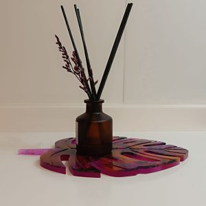 Suspiro de Otoño es un posavasos/porta velas artesanal elaborado con resina epoxi. Su forma de hoja y sus vibrantes matices rosados y naranjas evocan la calidez de la temporada otoñal. Un toque único y creativo para tu decoración.