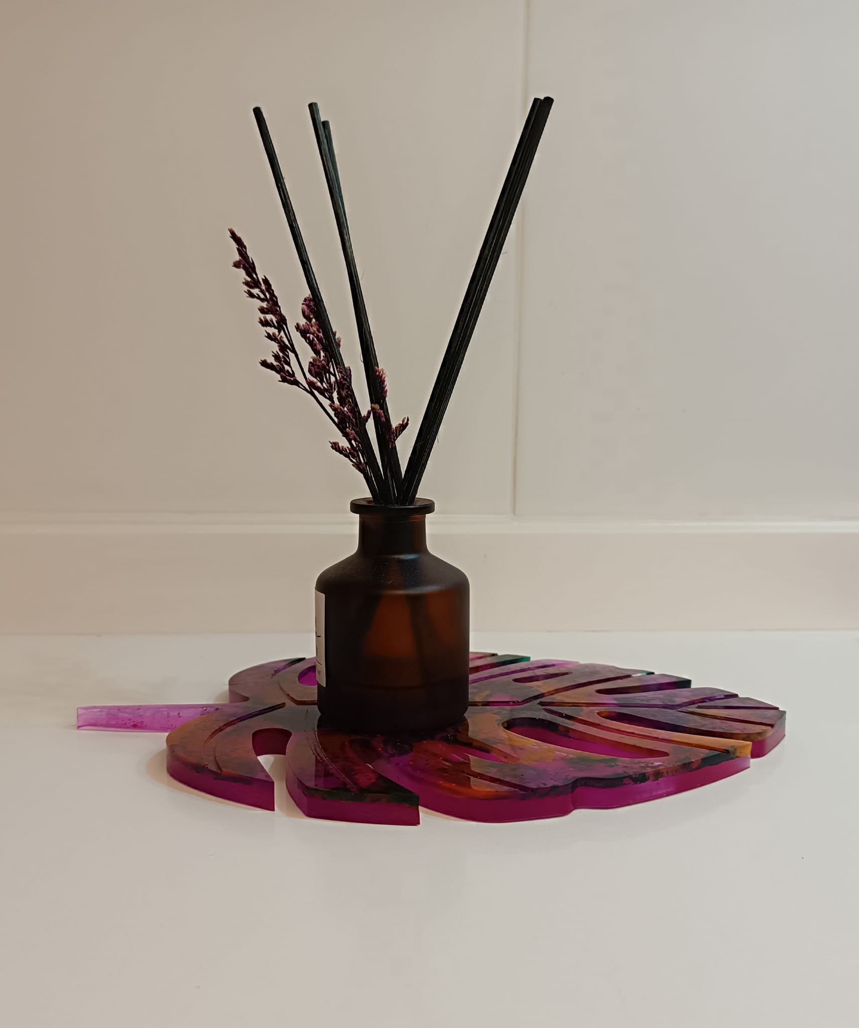 Suspiro de Otoño es un posavasos/porta velas artesanal elaborado con resina epoxi. Su forma de hoja y sus vibrantes matices rosados y naranjas evocan la calidez de la temporada otoñal. Un toque único y creativo para tu decoración.