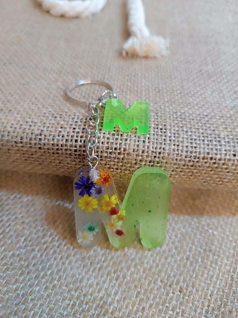 Llavero artesanal de resina epoxi «Letra Botánica». Inicial personalizada con flores encapsuladas y detalles vibrantes. ¡Un toque único para tus llaves!